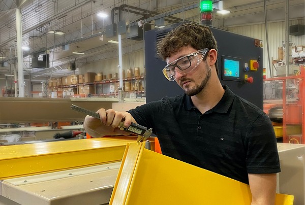 Employee working with a large plastic profile